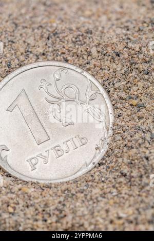 Nahaufnahme einer Rubel-Münze auf Sand. Für den Zusammenbruch von Ruble trifft Ruble den Tiefpunkt, was die russische Kriegswirtschaft, die russischen Schulden und die persönlichen Finanzen zum Scheitern bringt Stockfoto