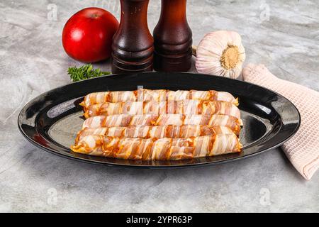 Rohe Würstchen, in Speck gewickelt, zum Grillen Stockfoto