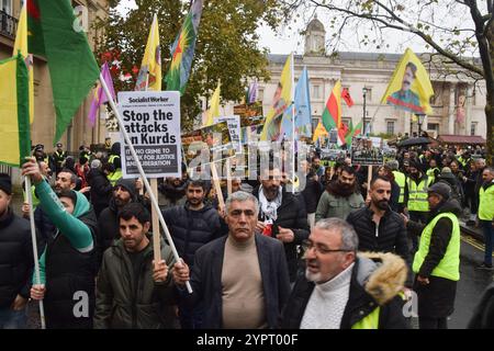 London, Großbritannien. Dezember 2024. Demonstranten auf dem Trafalgar Square halten Plakate zur Unterstützung der Kurden während der Demonstration. Die Demonstranten marschierten solidarisch mit den Kurden als Reaktion auf die jüngsten Festnahmen von Mitgliedern der kurdischen Gemeinschaft in London durch die Anti-Terror-Polizei. Quelle: SOPA Images Limited/Alamy Live News Stockfoto