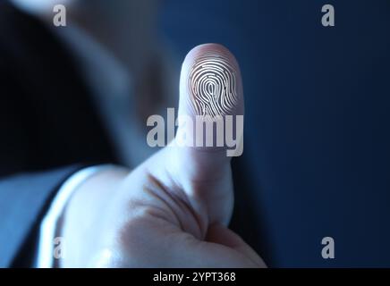 Frau, die den Finger auf die Oberfläche drückt, zeigt Reibungsrippen, Nahaufnahme. Fingerabdruck wird gescannt Stockfoto