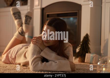 Frau in warmen Socken, die sich zu Hause am Kamin ausruhen Stockfoto