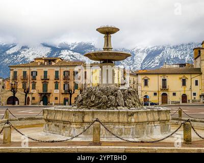 Der Brunnen auf der Piazza Garibaldi in Sulmona mit schneebedeckten Bergen im Hintergrund Stockfoto