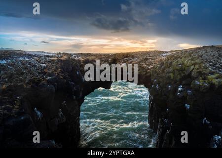 Blick auf die Steinbrücke bei Sonnenaufgang im Winter. Arnarstapi, Halbinsel Snæfellsnes, Island, Nordeuropa. Stockfoto