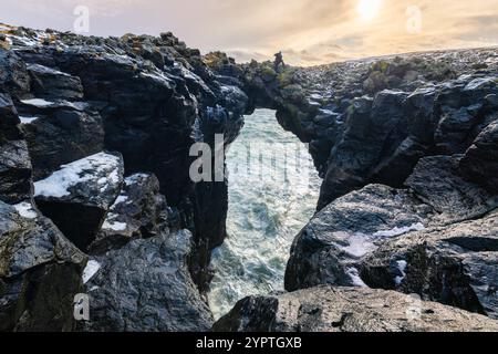 Blick auf einen Fotografen, der auf der Steinbrücke steht. Arnarstapi, Halbinsel Snæfellsnes, Island, Nordeuropa. Stockfoto