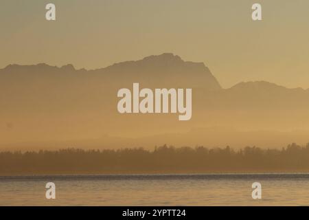 Ambach, Bayern, Deutschland, 01. Dezember 2024: Ein Wintertag beim Ambach / Münsing Landkreis Bad Tölz-Wolfratshausen. Hier der Blick beim Naherholungsgebiet auf den Sonnenuntergang, Sundown und den Starnberger See,im Dunst die Zugspitze, Wettersteingebirge *** Ambach, Bayern, Deutschland, 01 Dezember 2024 Ein Wintertag im Ambach Münsing Bezirk Bad Tölz Wolfratshausen hier der Blick auf das Naherholungsgebiet auf den Sonnenuntergang, Sonnenuntergang und den Starnberger See, im Dunst die Zugspitze, Wettersteingebirge Stockfoto