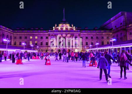 London, Großbritannien. Dezember 2024. Die Eislaufbahn im Somerset House sieht mit ihren farbenfrohen Lichtern hübsch aus, während die Menschen ihr festliches Schlittschuhlaufen auf dem Gelände des historischen Wahrzeichens genießen. Quelle: Imageplotter/Alamy Live News Stockfoto