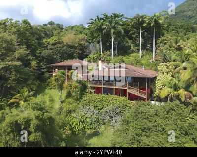 Blick aus der Vogelperspektive auf luxuriöses Holzhaus in tropischem Wald umgeben von Bäumen. Luxuriöse Villa und geräumiger Pavillon, Brasilien, Südamerika Stockfoto