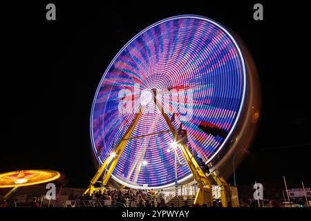 Eine bunte fröhliche Runde mit Leuten drauf. Die Lichter sind an und die Leute genießen sich Stockfoto