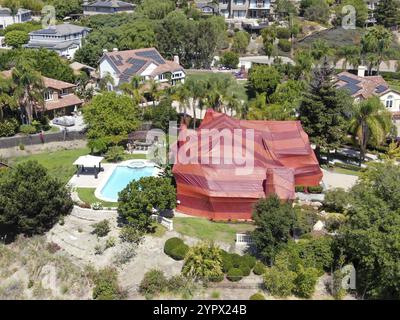 Blick aus der Vogelperspektive auf die Wohnvilla, die mit einem roten Zelt bedeckt ist, während sie für Termiten begasst wird. Encinitas, Kalifornien, USA. September 2020 Stockfoto