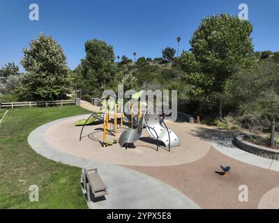 Farbenfrohe Kinderspielplätze im öffentlichen Park, umgeben von grünen Bäumen in San Diego, Kalifornien Stockfoto