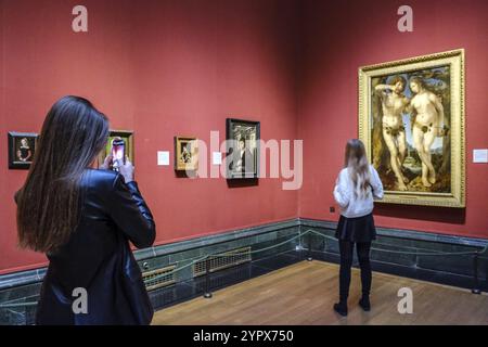 Jan Gossaert (Jean Gossart), Adam und Eva, Öl auf Holz, zwei junge Mädchen, die vor dem Gemälde fotografieren, National Gallery, London, England, GRE Stockfoto