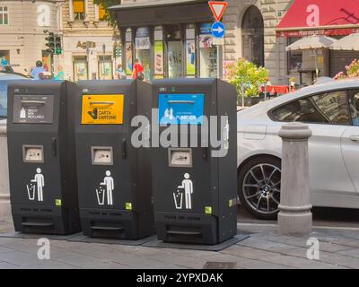 Triest, Italien - 29. Juni 2024: Drei sortierte öffentliche Mülltonnen in der Via Cesare Battisti. Stockfoto