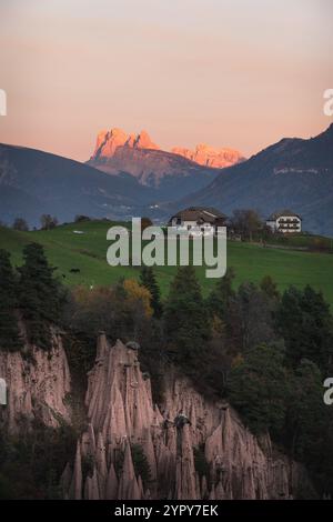 Ein fantastischer Sonnenuntergang mit Erdpyramiden im Vordergrund und dolomitischen Bergen im Hintergrund und einem winzigen Himmel Stockfoto