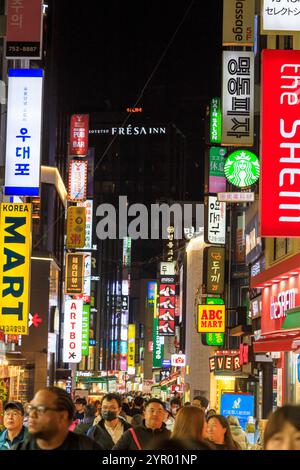 Seoul, Südkorea - 26. Oktober 2024: Straßenszene des belebten und lebhaften Einkaufsviertels Myeong-Dong bei Nacht mit beleuchteten Schildern, Locate Stockfoto