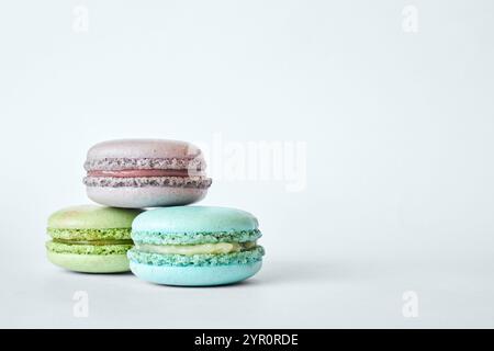 Stapel von drei farbenfrohen französischen Macarons, Kuchen mit verschiedenen Aromen in einer Pyramide, Minze, Apfel, Johannisbeere. Hausgemachtes Dessert, Makronen A Stockfoto