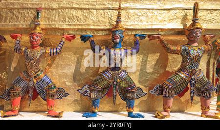 Yaksha Dämon Statuen mit dem goldenen Chedi im Tempel des Smaragd Buddha, Grand Palace, Bangkok, Thailand Stockfoto