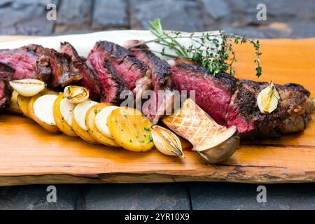La Côte de boeuf ' Tomahawk ' oder Black Angus Tomahawk Steak mit gegrillten Stachelpilzen und Medaillons Kartoffeln. Stockfoto