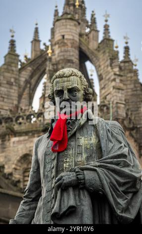 Edinburgh, Großbritannien. November 2024 30. Edinburgh, Schottland Rote Schals sind auf einigen der berühmten Statuen der Altstadt von Edinburgh zu sehen, darunter Adam Smith und James Braidwood (1800–1861). Das Bild zeigt den Zustand von Adam Smith, Statue von Adam Smith, dem „Vater der Wirtschaft“ und Autor des bahnbrechenden „The Wealth of Nations“, der 1776 veröffentlicht wurde, dem Jahr, als die USA die Unabhängigkeit erklärten. Die Bronzestatue befindet sich vor der St. Giles Cathedral auf der Royal Mile Picture von phil wilkinson/Alamy Live News Stockfoto