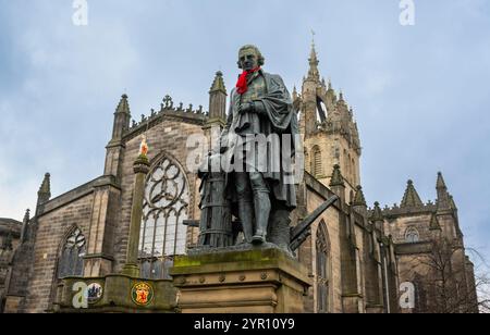 Edinburgh, Großbritannien. November 2024 30. Edinburgh, Schottland Rote Schals sind auf einigen der berühmten Statuen der Altstadt von Edinburgh zu sehen, darunter Adam Smith und James Braidwood (1800–1861). Das Bild zeigt den Zustand von Adam Smith, Statue von Adam Smith, dem „Vater der Wirtschaft“ und Autor des bahnbrechenden „The Wealth of Nations“, der 1776 veröffentlicht wurde, dem Jahr, als die USA die Unabhängigkeit erklärten. Die Bronzestatue befindet sich vor der St. Giles Cathedral auf der Royal Mile Picture von phil wilkinson/Alamy Live News Stockfoto