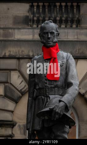 Edinburgh, Großbritannien. November 2024 30. Edinburgh, Schottland Rote Schals sind auf einigen der berühmten Statuen der Altstadt von Edinburgh zu sehen, darunter Adam Smith und James Braidwood (1800–1861). James Braidwood (1800–1861) war ein schottischer Feuerwehrmann, der 1824 der erste Master of Engines der weltweit ersten kommunalen Feuerwehr in Edinburgh war. Er war auch der erste Direktor des Londoner Feuerwehrbetriebs und wurde für die Entwicklung der modernen kommunalen Feuerwehr verantwortlich gemacht. Foto: phil wilkinson/Alamy Live News Stockfoto