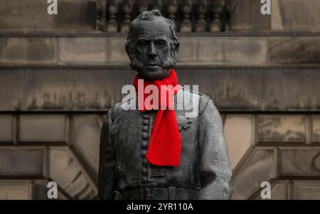 Edinburgh, Großbritannien. November 2024 30. Edinburgh, Schottland Rote Schals sind auf einigen der berühmten Statuen der Altstadt von Edinburgh zu sehen, darunter Adam Smith und James Braidwood (1800–1861). James Braidwood (1800–1861) war ein schottischer Feuerwehrmann, der 1824 der erste Master of Engines der weltweit ersten kommunalen Feuerwehr in Edinburgh war. Er war auch der erste Direktor des Londoner Feuerwehrbetriebs und wurde für die Entwicklung der modernen kommunalen Feuerwehr verantwortlich gemacht. Foto: phil wilkinson/Alamy Live News Stockfoto