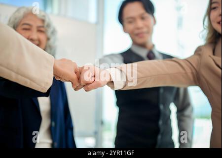 Eine Nahaufnahme verschiedener Geschäftsleute, die nach einem produktiven Meeting in einem modernen Büro mit Teamwork und Vertrauen zusammenstoßen. Einheit, Zweisamkeit, t Stockfoto