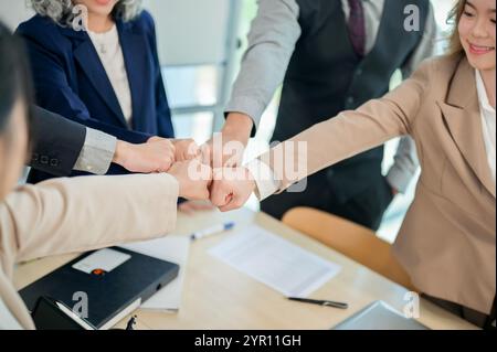 Eine Nahaufnahme verschiedener Geschäftsleute, die nach einem produktiven Meeting in einem modernen Büro mit Teamwork und Vertrauen zusammenstoßen. Einheit, Zweisamkeit, t Stockfoto