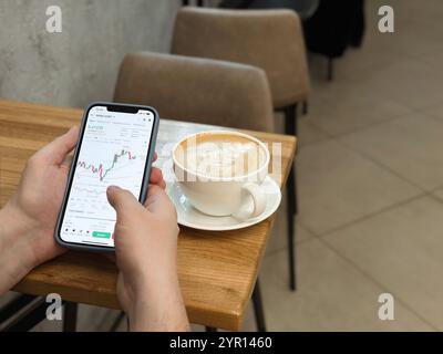 Nahaufnahme von männlichen Händen, die Smartphone Krypto Trading Chart drücken. Arbeit zu Hause und im Café, Fernarbeit. Analyse von Kryptowährung und Finanzproje Stockfoto