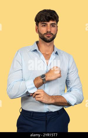 Selbstbewusster Geschäftsmann, der seine Hemdärmel hochkrempelt, bereit für Action Stockfoto