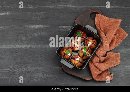 Im Ofen gebackene Feigen mit Camembert- oder Brie-Käse, Kräutern und Honig. Gesundes Essen, saisonales Obst, leckerer Snack. Schwarzer Holzhintergrund, Draufsicht Stockfoto