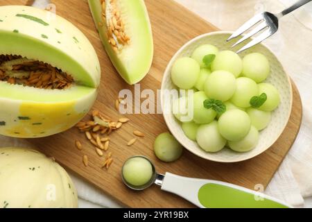 Melonenkugeln in der Schüssel und frisches Obst auf dem Tisch, Blick von oben Stockfoto