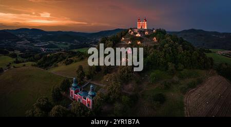 Banska Stiavnica, Slowakei - Panoramablick aus der Luft auf den wunderschönen beleuchteten barocken Kalvarienkalvaria in der Slowakei bei Dämmerung an einem Sommernachmittag mit Dramati Stockfoto