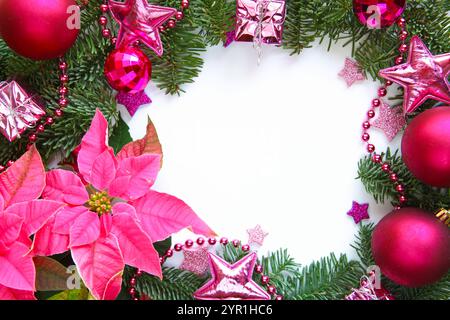 Festliches Weihnachtsarrangement mit rosafarbenen Weihnachtsstern, Tannenzweigen, rosa und Fuchsia-Ornamenten, glitzernden Sternen und Perlen mit leerem weißen Raum Stockfoto
