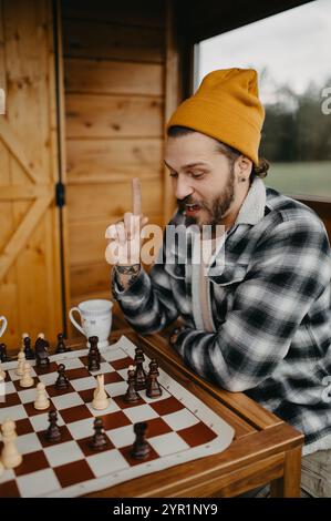 Gutaussehender junger Mann spielt Schach und hat draußen eine Lösung gefunden. Stockfoto