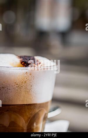 Nahaufnahme eines schäumenden Cappuccino in einem Glas Stockfoto