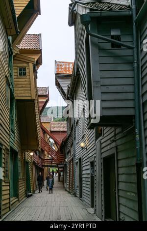 Bergen, Norwegen - 8. August 2022: Menschen schlendern durch die engen Gassen des berühmten und historischen Stadtviertels Brygge Stockfoto