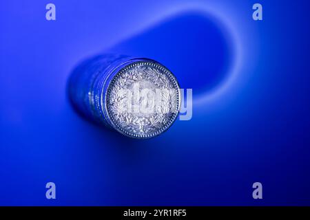 Ein Stapel von 20 Rappen Schweizer Franken-Münzen. Draufsicht, isoliert auf Blau, Nahaufnahme, keine Leute. Stockfoto