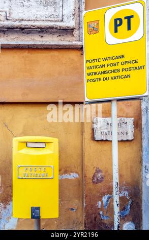 Neben einem Schild, das das Vatikanische Postamt in Rom anzeigt, befindet sich ein gelbes Postfach, das seine einzigartige Lage zeigt. Stockfoto