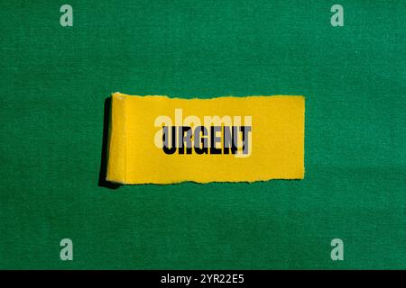 Dringende Nachricht auf gerissenem gelbem Papierstück mit grünem Hintergrund. Konzeptionelles dringendes Wortsymbol. Kopierbereich. Stockfoto