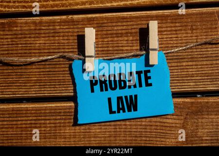 Nachlassgesetznachricht geschrieben auf gerissenem blauem, zerrissenem Papierstück mit hölzernem Hintergrund. Symbol für das konzeptionelle Nachlassgesetz. Kopierbereich. Stockfoto