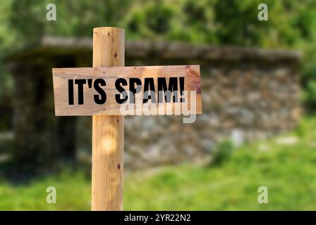 Es ist eine Spam-Nachricht auf hölzernem Schild mit verschwommenem Hintergrund. Konzeptionell ist das Spam-Symbol. Kopierbereich. Stockfoto