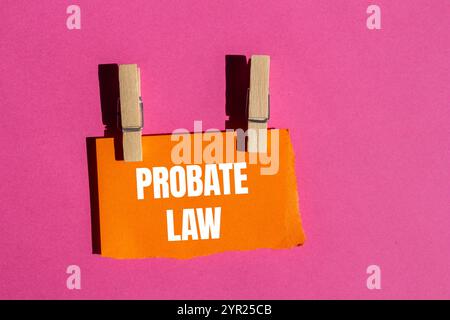 Nachricht zum Nachlassgesetz geschrieben auf gerissenem, gerissenem orangenem Papierstück mit rosa Hintergrund. Symbol für das konzeptionelle Nachlassgesetz. Kopierbereich. Stockfoto