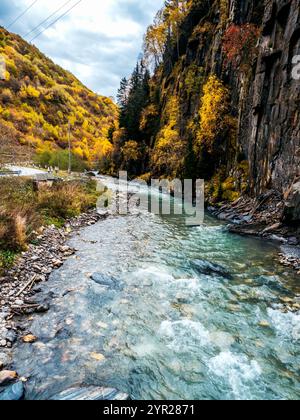 Fantastische Landschaft mit Süßwasserbach, wunderschönem geschwungenem Fluss, gelb grünem Waldberg auf blauem Himmel mit Wolken im Herbst in Georgia. Natur m Stockfoto