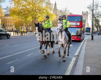 Pferdepolizisten laufen auf der Straße in Whitehall, Westminster, im Zentrum von London, Großbritannien Stockfoto