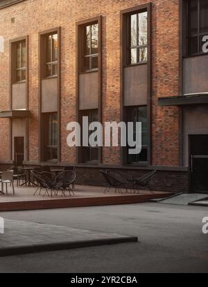 Fassade eines mit Klinkerziegeln verzierten Hauses. Café im Freien in der Innenstadt bei Sonnenuntergang. Stockfoto