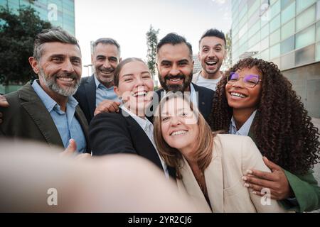 Selfie. Verschiedene Geschäftsleute lächeln und schauen während eines Meetings im Freien in die Kamera, um Teamarbeit zu zeigen. Erfolgreiche Geschäftsleute, die gemeinsam in der Innenstadt in die Kamera schauen. Hochwertige Fotos Stockfoto