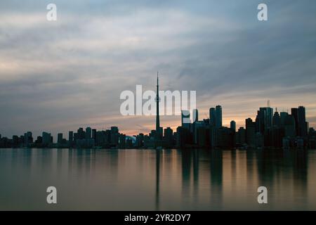 Die Skyline der Innenstadt von Toronto, wenn die Sonne untergeht, bevor die Lichter der Stadt die Wolkenkratzer erhellen. Toronto Islands auf der anderen Seite des Ontario Sees. Stockfoto