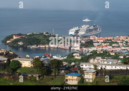 St. George's, Grenada - 4. Januar 2018: Kreuzfahrtschiffe legen am malerischen Hafen mit farbenfrohen Gebäuden und üppigem Grün an. Stockfoto