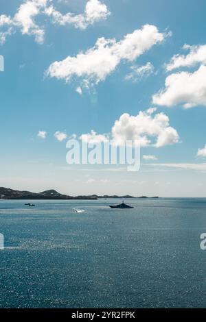 St. George's, Grenada - 4. Januar 2018: Ein ruhiger Blick auf das Karibische Meer mit Booten und fernen Inseln unter einem hellblauen Himmel. Stockfoto