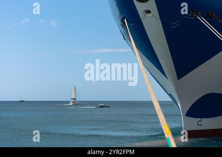 St. George's, Grenada - 4. Januar 2018: Ein großes Kreuzfahrtschiff mit kleineren Booten, die im Hintergrund segeln. Stockfoto